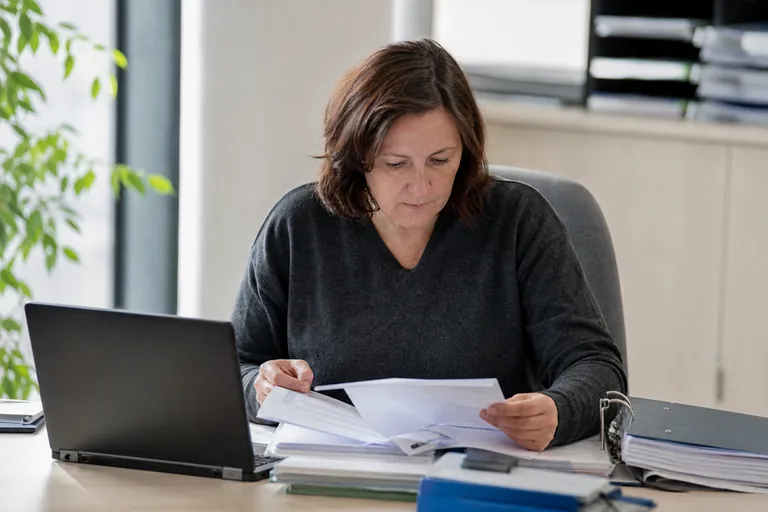 Datenschutzbeauftragte prüft Unterlagen zu Verarbeitungstätigkeiten an einem Schreibtisch